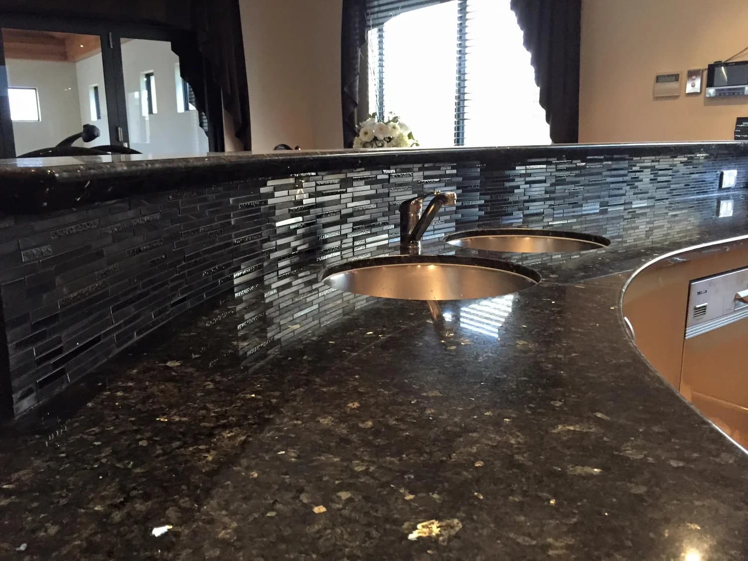 Kitchen fit-out with stone benchtops, undermount sinks and mosaic splashback