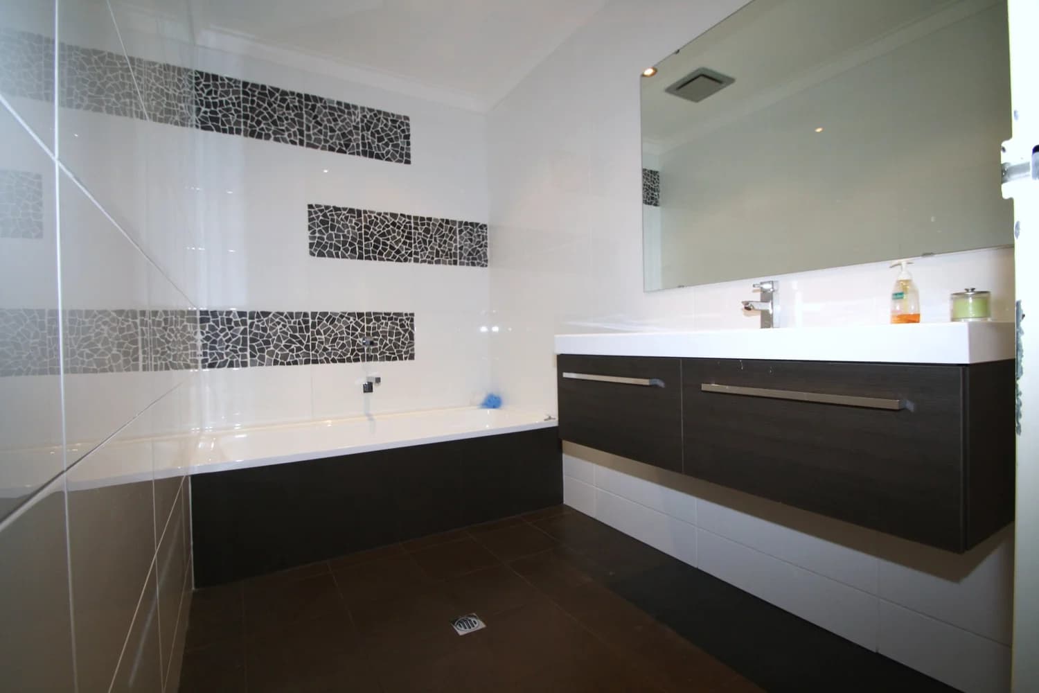 Family bathroom with feature mosaic tiling, bathtub and double vanity