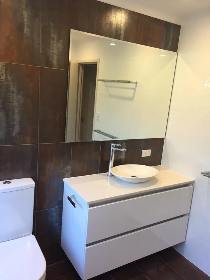 Bathroom with metallic feature tiling, vessel basin and floating vanity